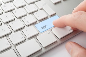 Electronic signature concept. Man press sign key on computer keyboard.